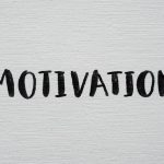 Inspirational word 'Motivation' in black on a white textured canvas background.